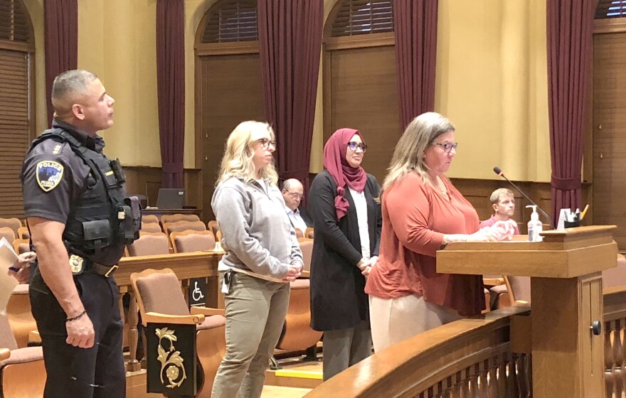 Christina Gerlach-Mooney stands at the podium as she provides details about the Peoria Police Department's co-response Social Services Unit to the city council as her team members and Police Chief Eric Echevarria stand behind her during Tuesday's city council meeting.