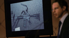 FILE - An image of the weapon used during the Newtown school shooting is displayed while attorney Josh Koskoff speaks during a news conference in Trumbull, Conn., Feb. 15, 2022. A federal judge on Thursday, Aug. 3, 2023, rejected a request to temporarily block Connecticut's landmark 2013 gun control law, passed after the Sandy Hook Elementary School shooting, until a gun rights group's lawsuit against the statute has concluded. (AP Photo/Seth Wenig, File)