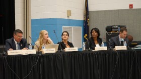 A photo of legislators sitting at a table in front of mics. 
