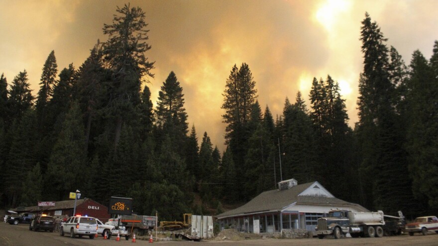 Smoke rises from a wildfire behind the Fish Camp General Store near Yosemite National Park in Fish Camp, Calif., last week. The wildfire is among many burning across the Western U.S.