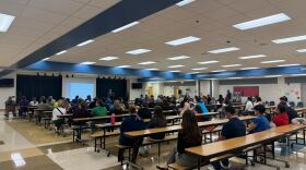 Close to a hundred people sit at cafeteria tables at McCoy Elementary School during one of the listening sessions from OCPS.