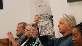 A concerned area resisdent holds up a sign during the Bradford County Commission meeting on Tuesday, April 7, 2026. (Madison Ginsberg/WUFT News)