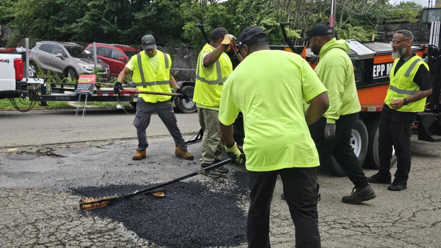 City of Buffalo employees fill a pothole on Fillmore Avenue using heat-treated asphalt.