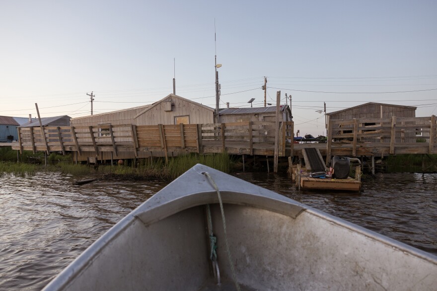 The Twitchell family returns home to Kasigluk after a boat ride on July 11, 2023. Their house (left) sinks lower every year due to thawing permafrost.