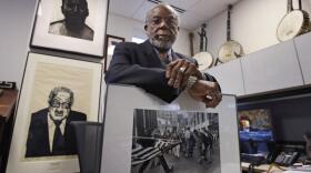 Theodore Landsmark, lawyer, architect and director of the Dukakis Center for Urban and Regional Policy at Northeastern University poses for a photo in his office in Boston, Tuesday, March 27, 2018. Pictured in Landsmark's office are a sketch of King, top left, a portrait of Supreme Court Justice Thurgood Marshall, bottom left, and a Pulitzer Prize-winning photograph by Stanley Forman, which shows Landsmark being assaulted in 1976 by a demonstrator carrying a flagpole bearing the American flag. (Charles Krupa/AP)