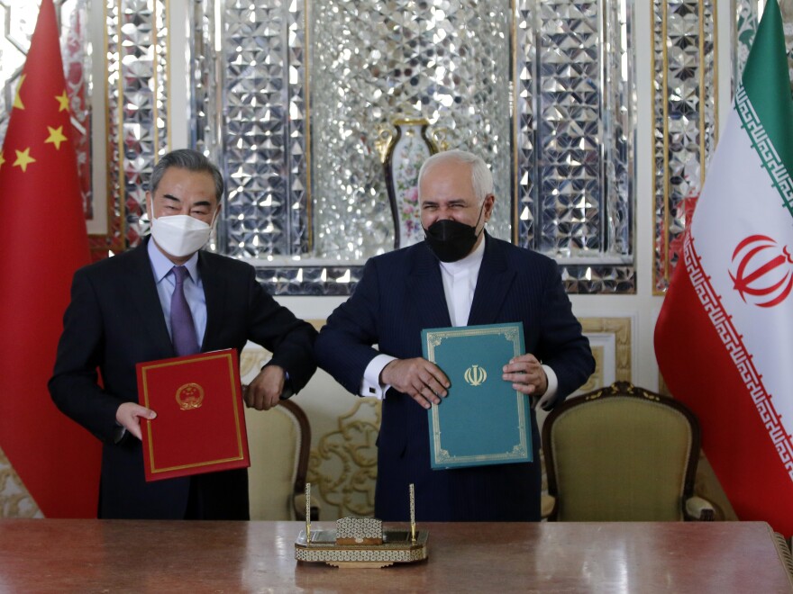 Iranian Foreign Minister Mohammad Javad Zarif and Chinese Foreign Minister Wang Yi pose for a photo after signing agreements in Tehran on March 27.