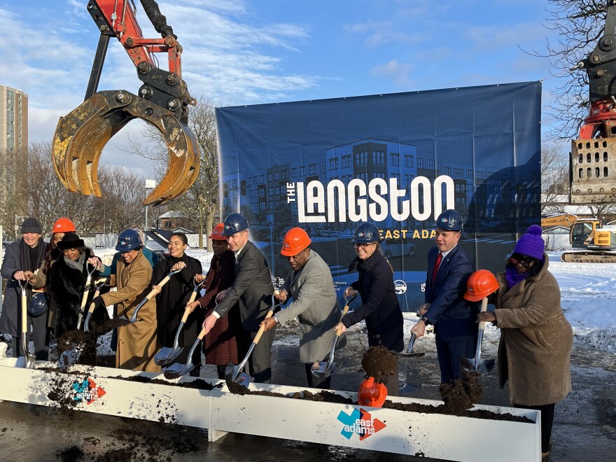 Numerous officials and stakeholders toss shovels of dirt to mark the groundbreaking of phase one of the East Adams project.