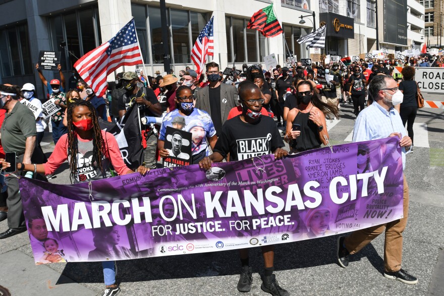 Protestors turn the corner from 12th Street onto Grand Blvd. on Friday afternoon shortly after launching their March on Kansas City toward the World War I Museum and Memorial.