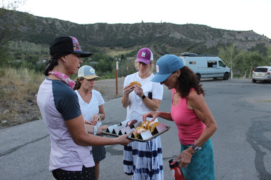 Ann Driggers serves homemade pulled pork tacos to the Girls Outside group in the Snowmass Village mall parking lot after a bike ride on Aug. 4, 2026.