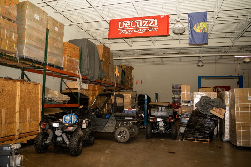 cramped warehouse with ATVs and boxes.