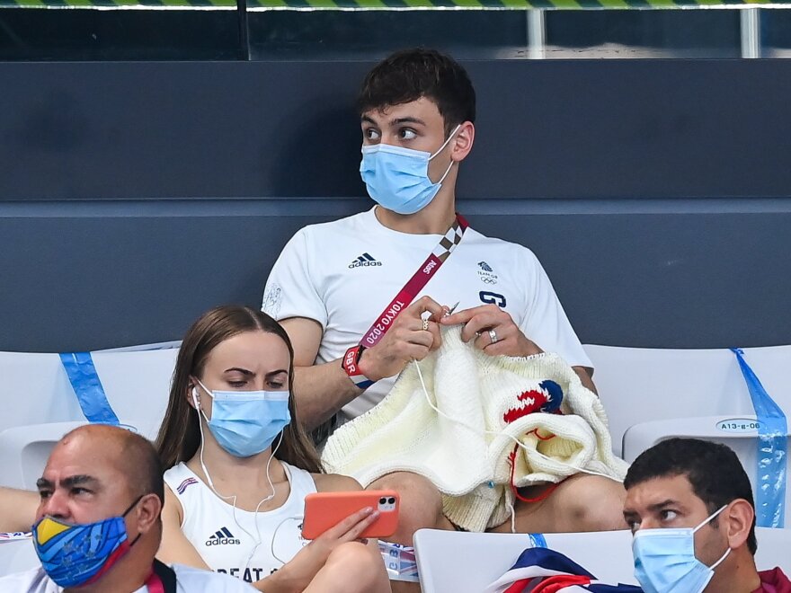 Tom Daley of Great Britain knits during the preliminary round of the men's 3m springboard at the Tokyo Aquatics Centre on day ten of the 2020 Tokyo Summer Olympic Games.