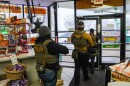 FILE — Immigration and Customs Enforcement agents walk through a gas station on Feb. 5, 2026, in Minneapolis.