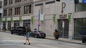 A woman crosses Boulevard of the Allies in front of a Point Park University building.