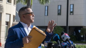Eleazar Guevara, a nine-year Doral resident, holds a folder he says contain 160 signatures — collected from community members opposed to the city's ICE agreement — outside Doral Government Center on Wednesday, Oct. 7, 2026.