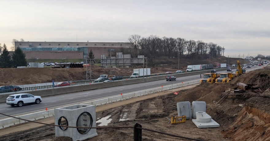 Cars and trucks drive through a construction zone.