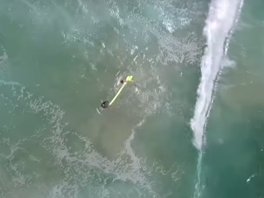 An unmanned aircraft piloted by a lifeguard dropped a yellow floating tube to two distressed swimmers off Australia's Far North Coast in New South Wales.