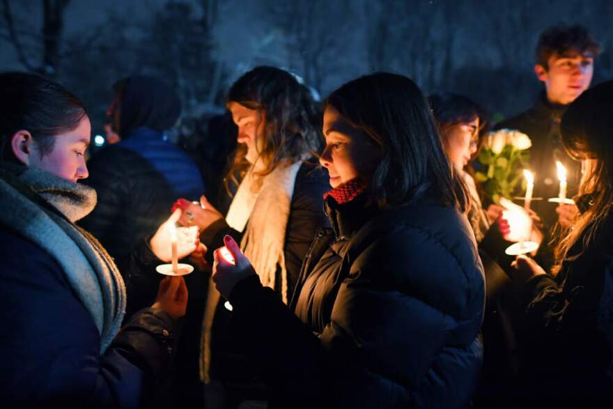 People hold candles during a vigil, Sunday, Dec. 14, 2025, in Providence, R.I., for the victims of Saturday's shooting on the campus of Brown University. (Steven Senne/AP)