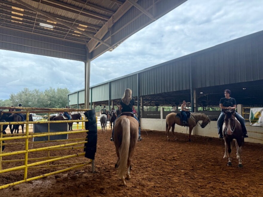 Competitors practice during exhibition runs at the PacWest Barrel Racing event. Riders pay $5 per turn to warm up their horses and familiarize them with the arena before competition.