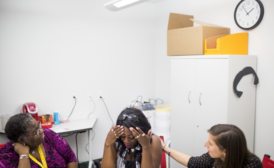 Jalanda Blackmon (left), and Caroline Smith (right), offer congratulations and support to Katina Johnson as she becomes emotional during an advising session for higher education options at the Goodwill Excel Center.