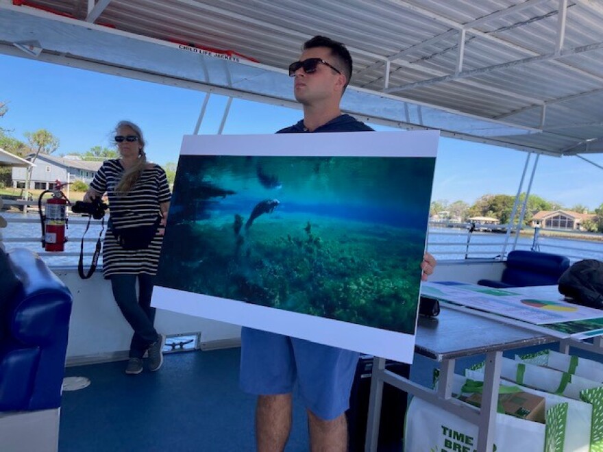 Michael McGrath of the Florida Sierra Club shows a photo of a manatee swimming in an algae-choked spring