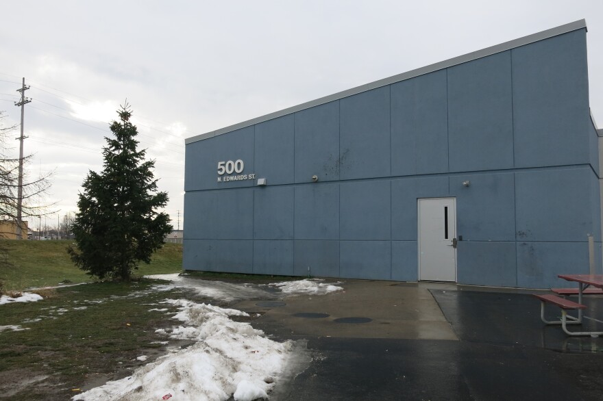 blue building with no windows that says 500 North Edwards, melting snow and a picnic table
