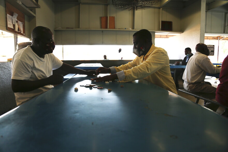 Tony Brutus, left, got vaccinated at the taxi parking lot at Miami International Airport on May 10, 2021, which allowed him to go play dominos with other vaccinated drivers.