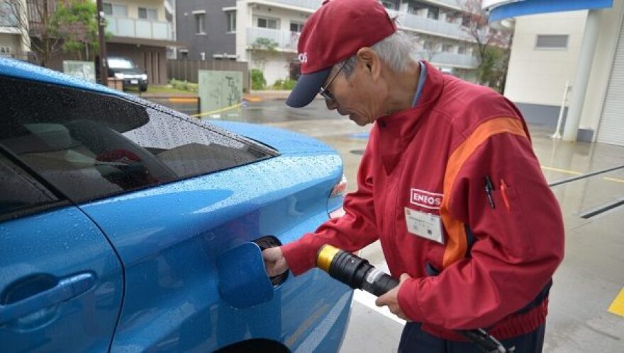 Hydrogen fuel station attendant Ken Kawakatsu fills the tank with hydrogen gas cooled to minus 35 degrees celsius. He says this Tokyo station gets about a dozen customers a day. (Hiroo Saso for StateImpact Pennsylvania)