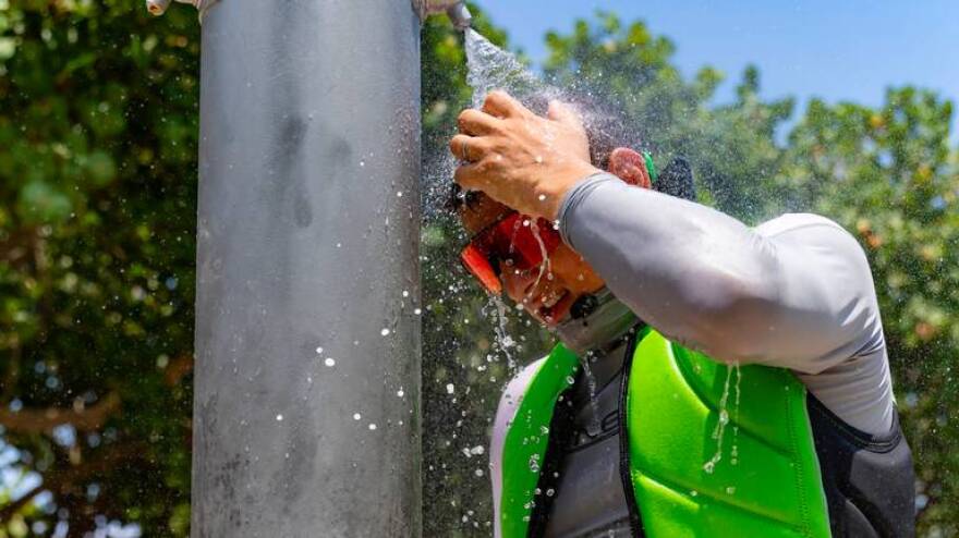 Beachgoer Sergei lazovskiy cools off under the shower after enjoying the sunny and hot day at the Haulover Park Beach at on Tuesday, May 28, 2024, in Miami Beach, Florida.