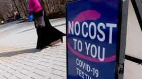 A person walks past a COVID-19 testing location in Arlington, Va., on March 16. A new website launched by the Biden administration will provide a locater for test-and-treat facilities, among other services.