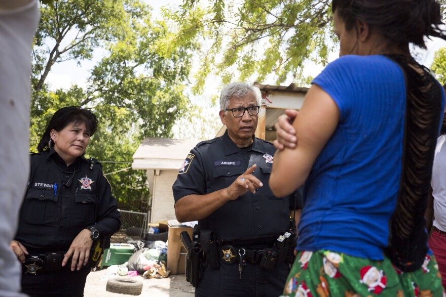 Deputies Theresa Stewart and Juan Arispe with the Travis County Constable Precinct 3 speak to a woman in 2018 after she is evicted from a home in Southwest Austin. Several residents of the home had been served a notice to vacate following an eviction suit.