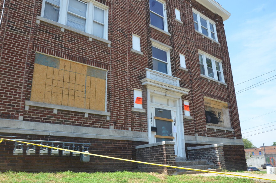 An apartment building is boarded up.