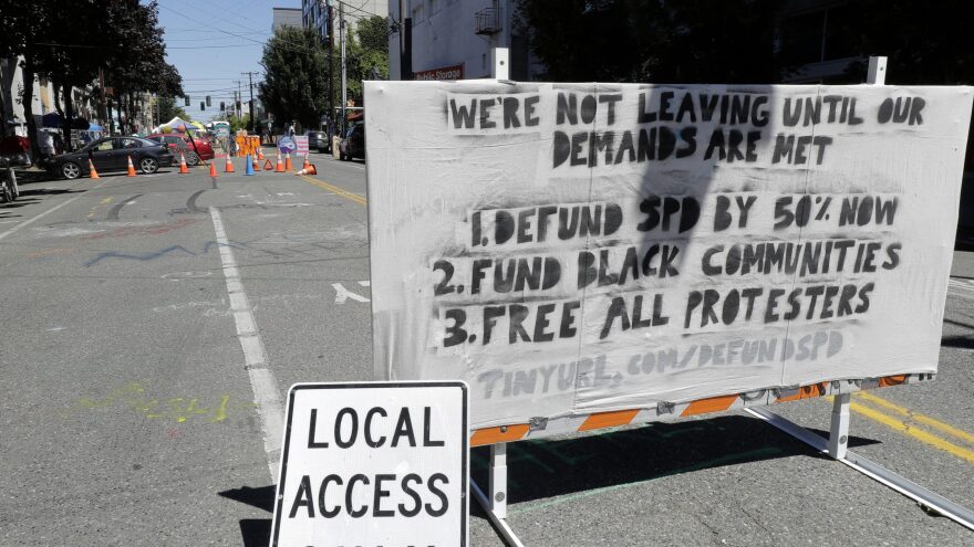 The Seattle Police Department will return to their East Precinct building "in the near future," Mayor Jenny Durkan says. Here, a sign on a street barricade lists protesters' demands in the Capitol Hill Occupied Protest zone, where two shootings took place over the weekend.