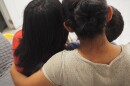 photo taken from behind a woman hugging her children on the couch