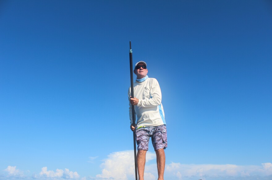 Capt. Jamie Allen steers a flats boat using a push pole in Boca Grande, Florida, in August 2025. (Rylan DiGiacomo-Rapp/WUFT News)