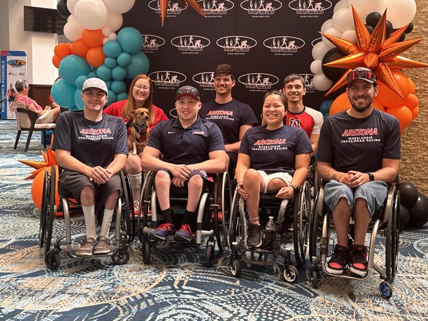 Group of people in wheelchairs in front of decorative background
