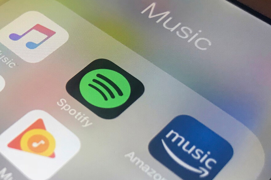 Icons of music streaming platforms on a phone screen.