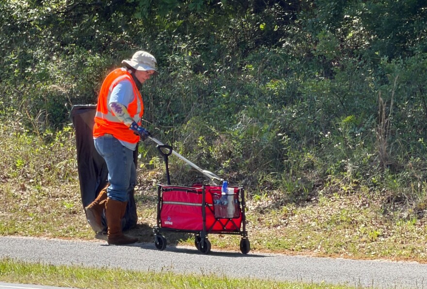 Yoga Club leader Michael Delaney picking up trash alongside U.S. 27 as part of the Adopt-a-Highway volunteer program. (Alyssa Britton-Harr/WUFT News)