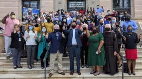 A group of people wearing masks all give a thumbs up.