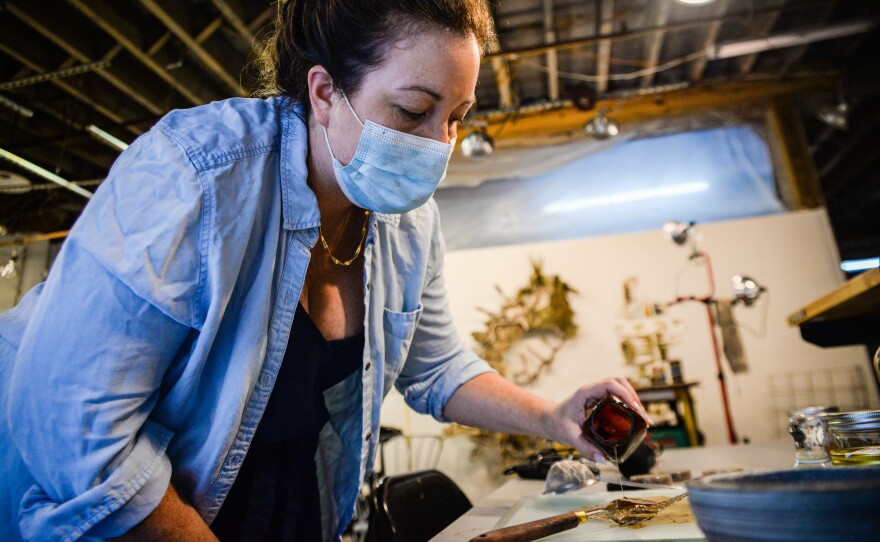 Heather Bird Harris pours gum arabic over wetlands soil that she turns into watercolor for paintings about Louisiana's eroding coast on Dec. 12, 2022.