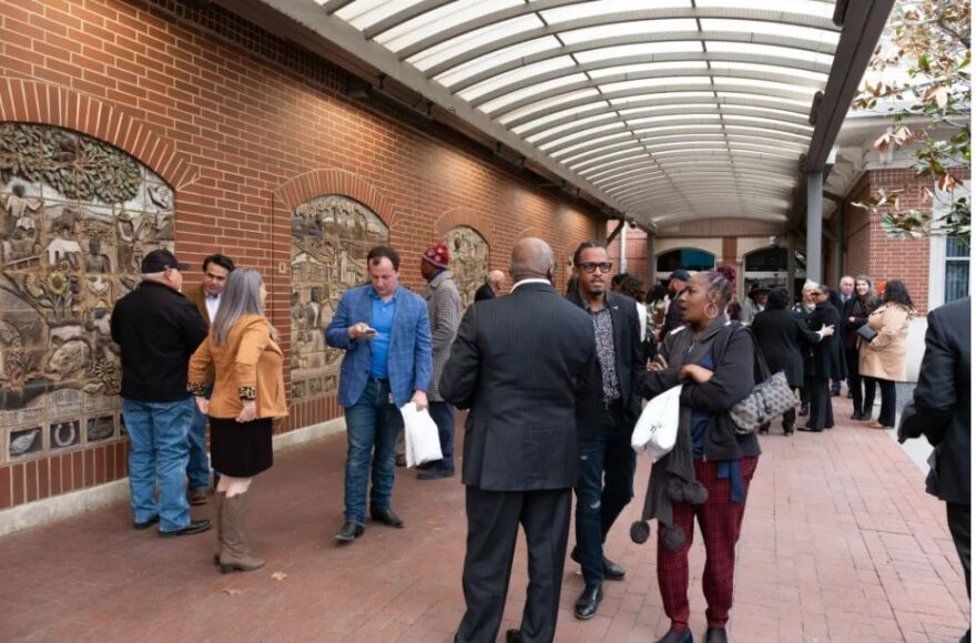 Attendees gather around the art installation at the ceremony celebrating the 22nd anniversary of the Historic Wall at the Fort Worth Central Station on Feb. 28, 2024.