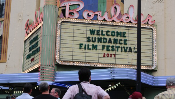 Outside of a theatre where a crowd has gathered. On the theatre's sign it says "WELCOME SUNDANCE FILM FESTIVAL 2017"