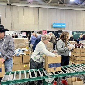 Volunteers at the American Farm Bureau Convention in an assembly line, boxing food for families in the Midwest.