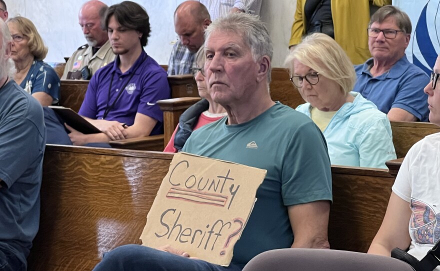 An attendee holds a sign during a Crow Wing County Board meeting in which members of the public shared concerns about the county's relationship with Immigration and Customs Enforcement on Tuesday, June 23, 2026, at the Historic Courthouse in Brainerd.