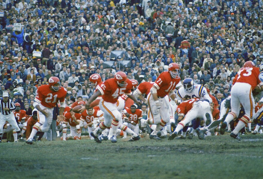 In this Jan. 11, 1970, file photo, Kansas City Chiefs quarterback Len Dawson prepares to handoff to running back Mike Garrett (21) as running back Robert Holmes (45) and guard Ed Budde (71) lead the play during the Super Bowl in New Orleans.