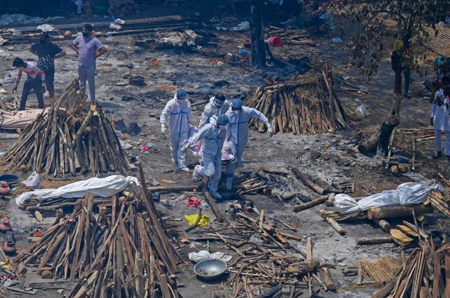 Family members and relatives perform last rites amid the funeral pyres for COVID-19 decedents at a New Delhi crematorium.