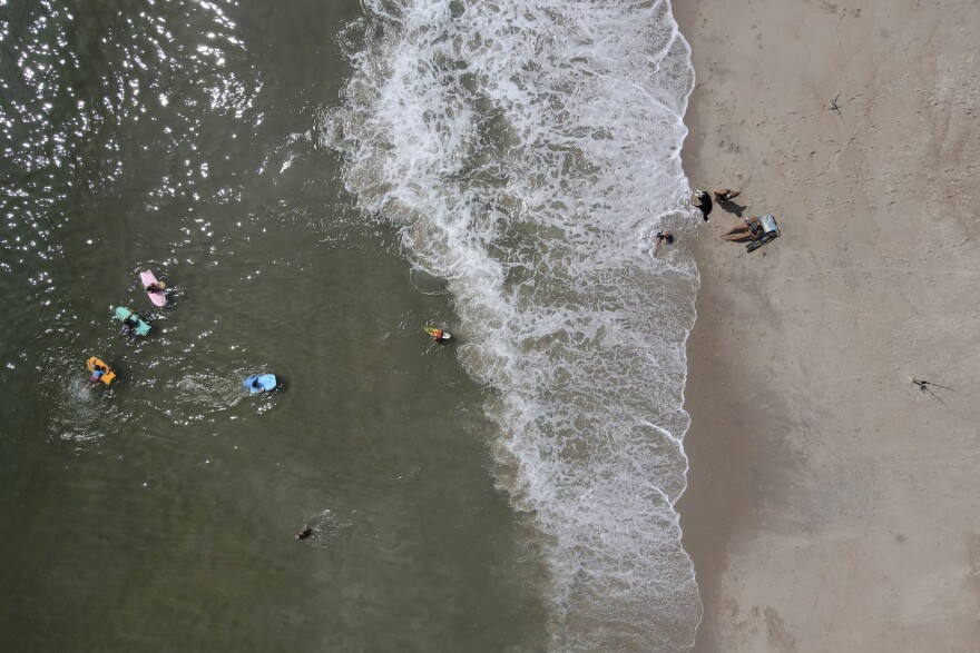 Beachgoers enjoy a hot day along the Atlantic Ocean, Saturday, July 18, 2020, in Rehoboth Beach, Delaware. (Julio Cortez/AP)