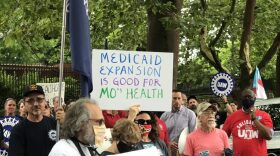 Demonstrators stand outside of the Governor’s Mansion in Jefferson City on July 1, 2021 and hold signs urging Gov. Mike Parson to fund voter-approved Medicaid expansion. 