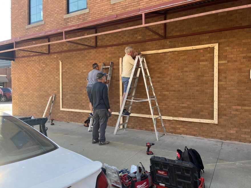Workers from Great Expectations Renovations install the frame for the new mural.