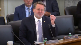 U.S. Senator Gary Peters of Michigan holds up a microchip at a committee hearing on the Chips Act in March 2022.