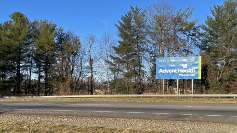 A western North Carolina hospital was supposed to be built and running by 2025, but the state's certificate of need law has been used to delay the project for years. A sign in the mountain region heralds the coming hospital, but the site behind it is just a field of dirt.